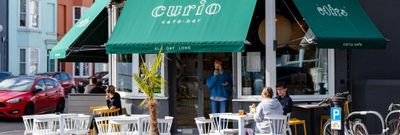 Exterior photo for Curio on a sunny day with the green signeage.