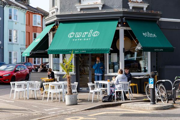 Exterior photo for Curio on a sunny day with the green signeage.