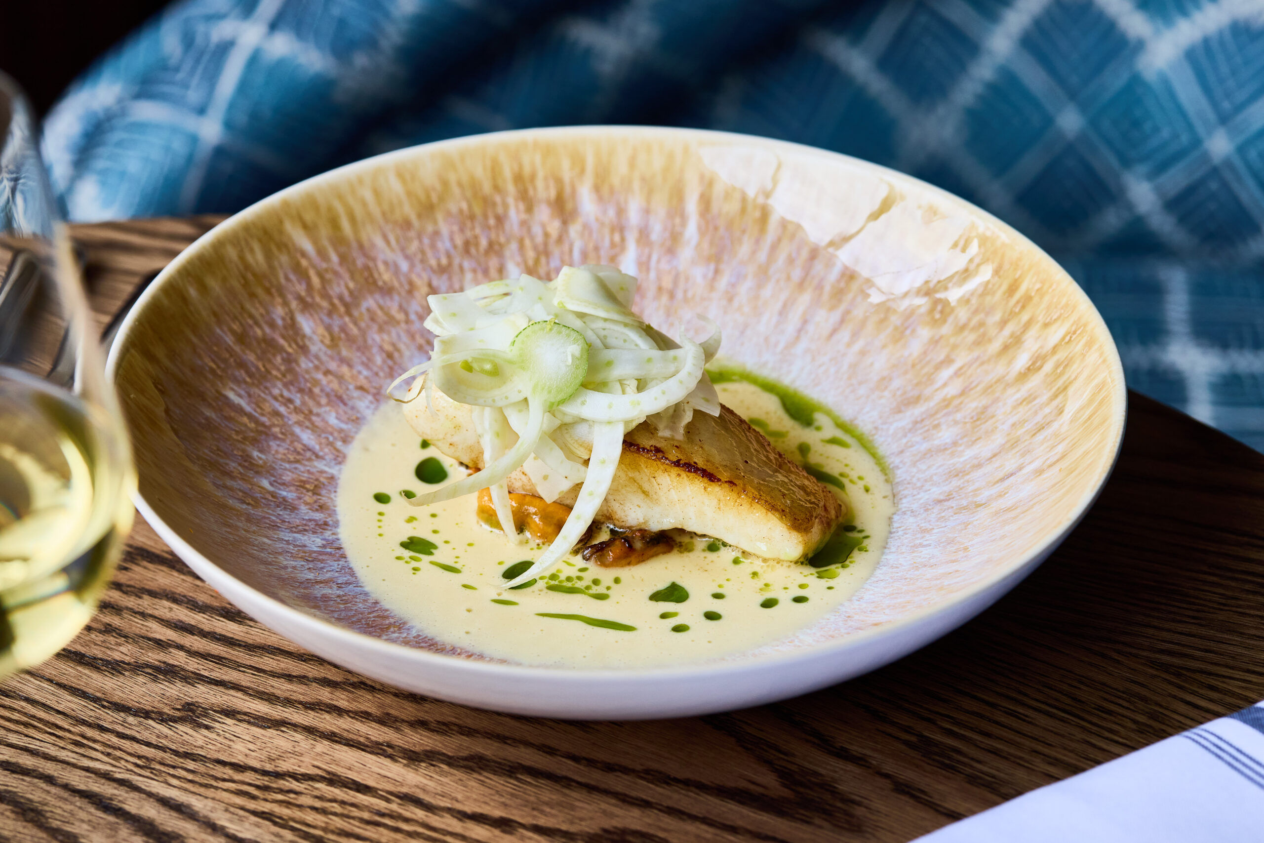 halibut dish served in round beige plate at Le Flamant
