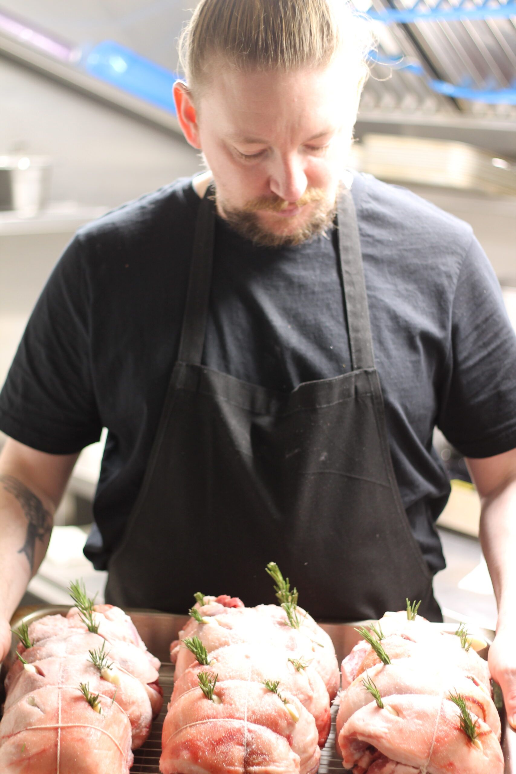 Sunday Roasts being prepared at The Duck Inn with chef holding cuts of meat