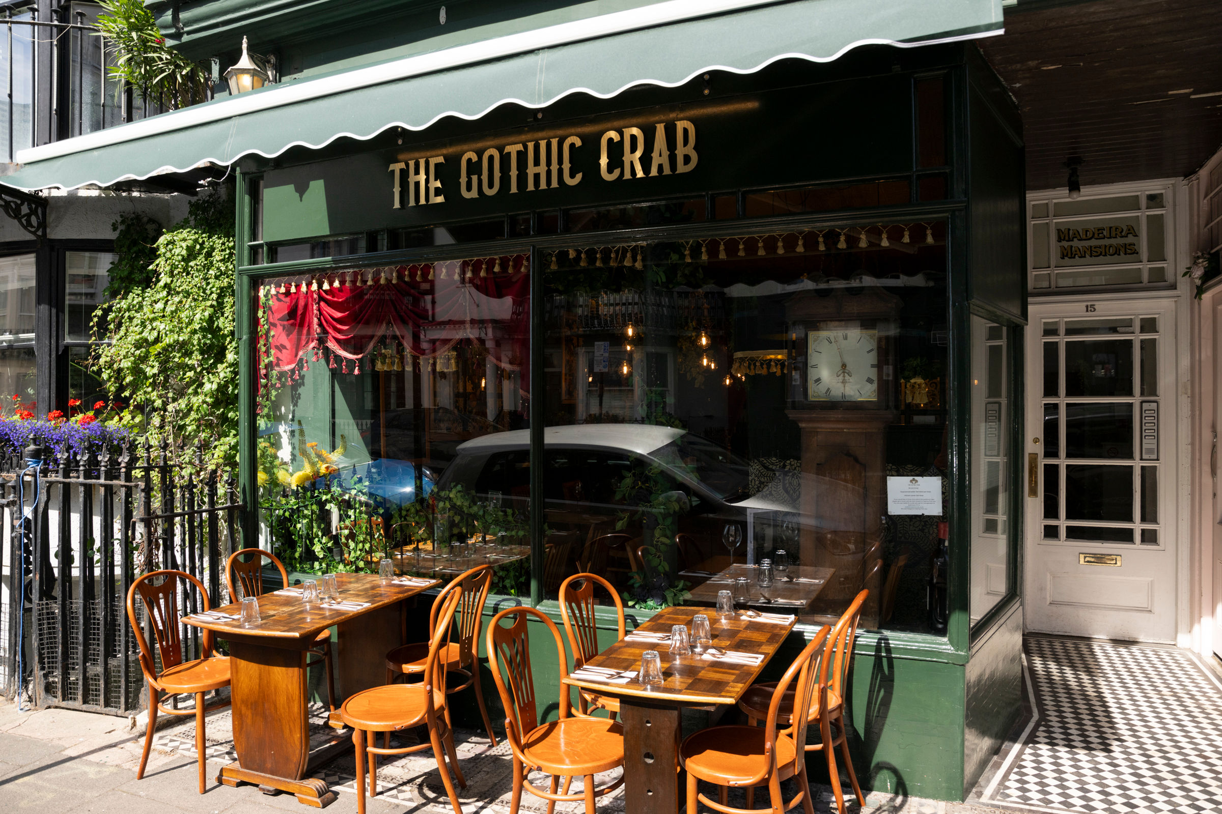 The Gothic Crab - exterior shot of the restaurant located in Kemptown, dark green walls and brown chairs and tables