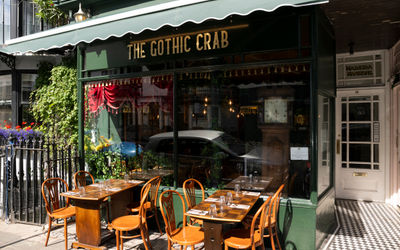 The Gothic Crab - exterior shot of the restaurant located in Kemptown, dark green walls and brown chairs and tables