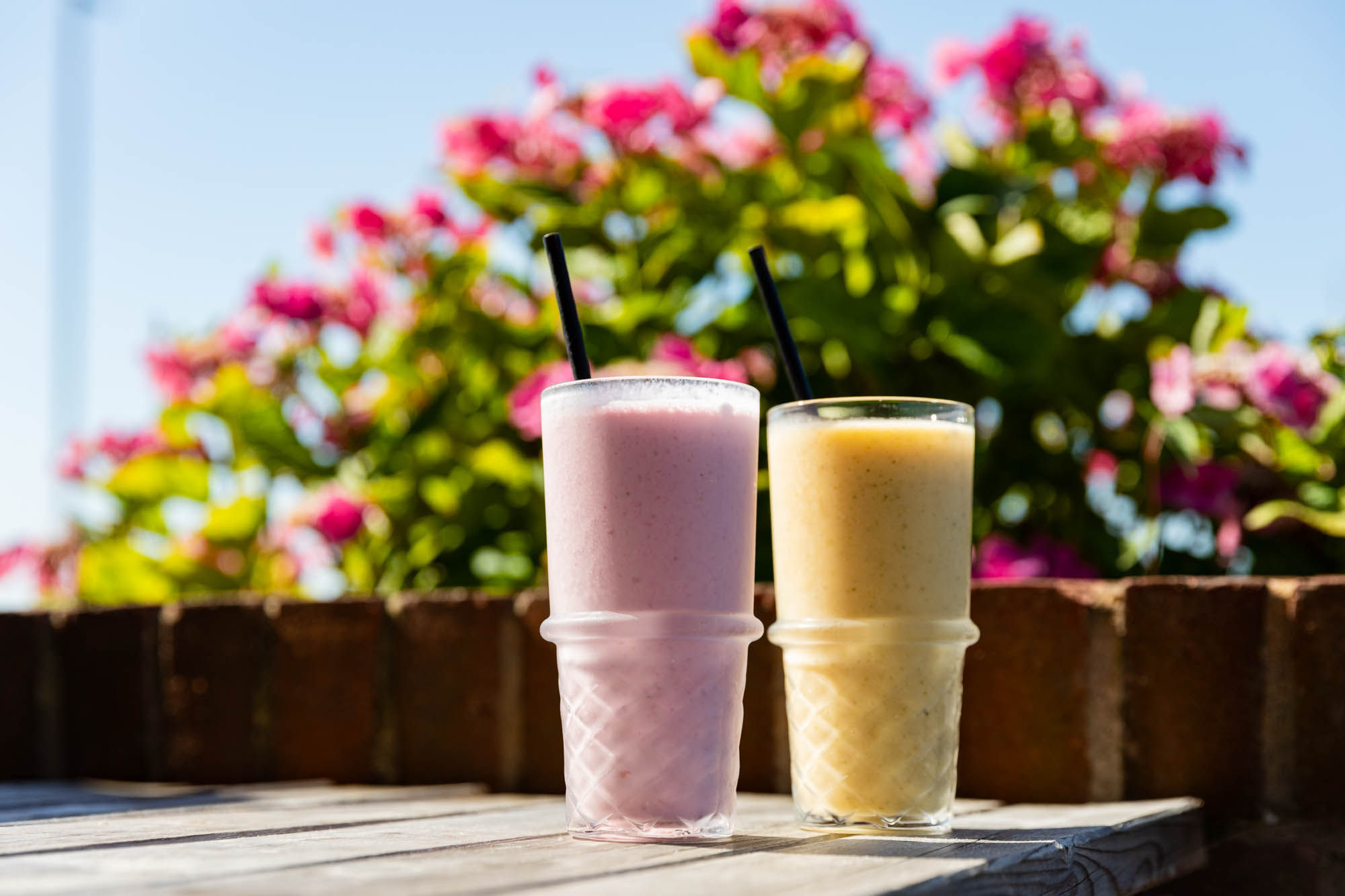 pink and yellow smoothie on the table outside