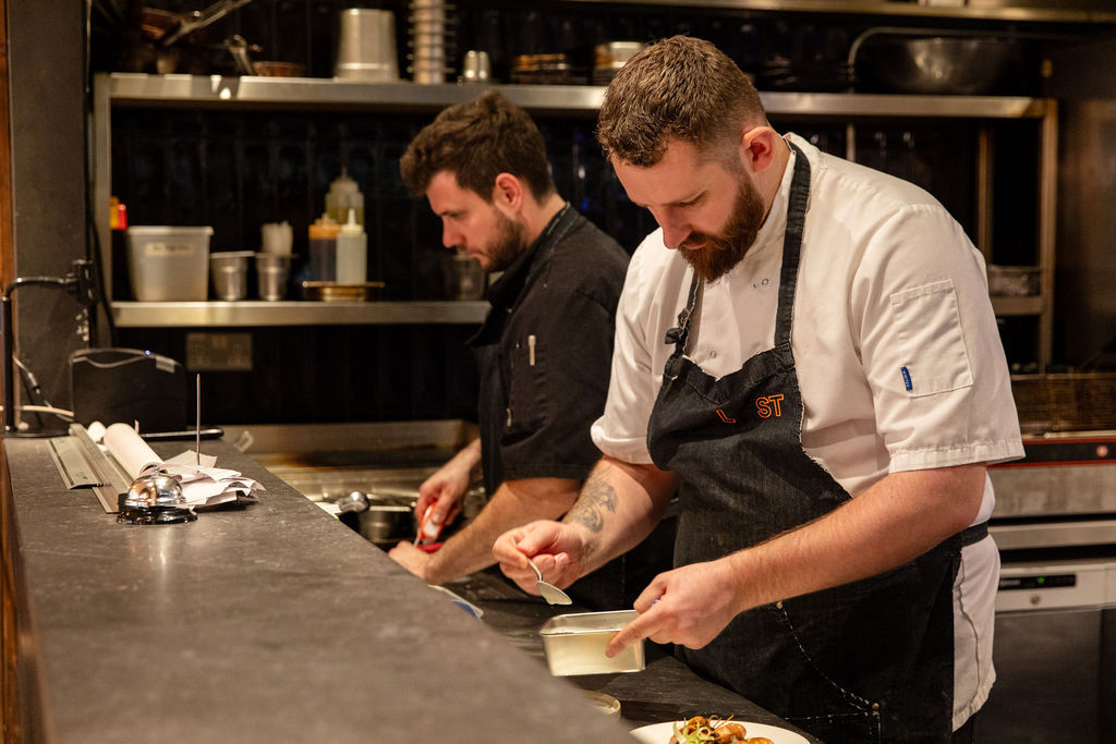 Chefs at the pass in the restaurant kitchen.