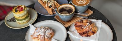 cakes, pastires and two coffee served on the table at Jacobs Bakery