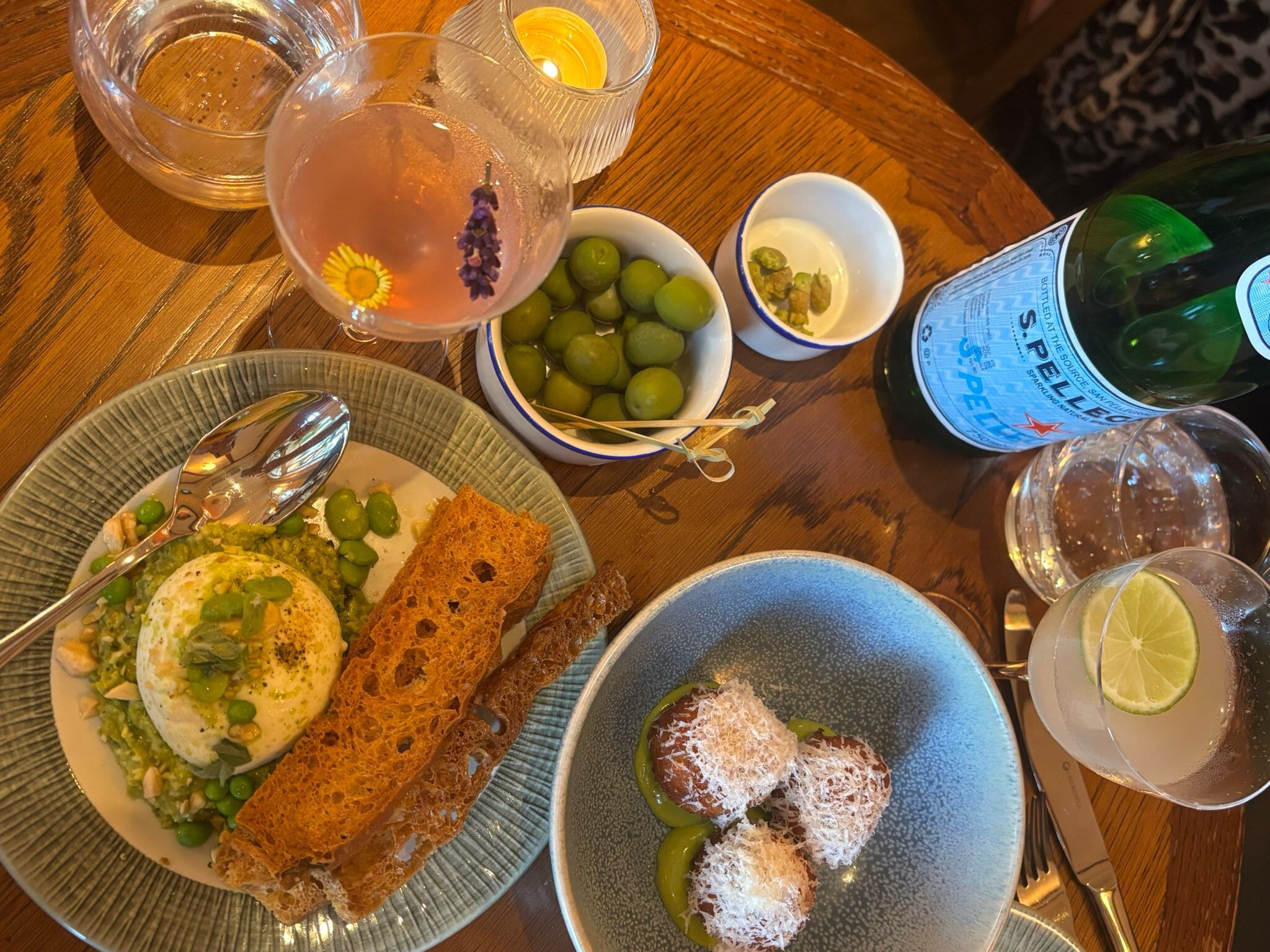 over head shot of the table laid out with couple of small dishes including arancini, olives and drinks. Italian-inspired cuisine at Tutto Brighton