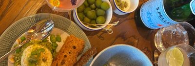 over head shot of the table laid out with couple of small dishes including arancini, olives and drinks