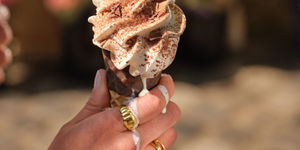 hand holding chocolate ice cream that is melting