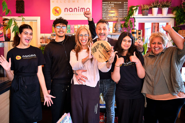 The team celebrating their BRAVO win inside their cafe.