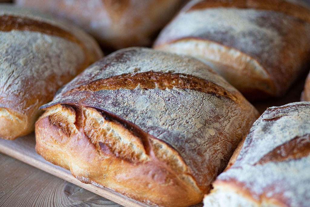 a loaf of bread at the Open Bakery Brighton. The loaf is an uncut slice and is located on the shelves. 
