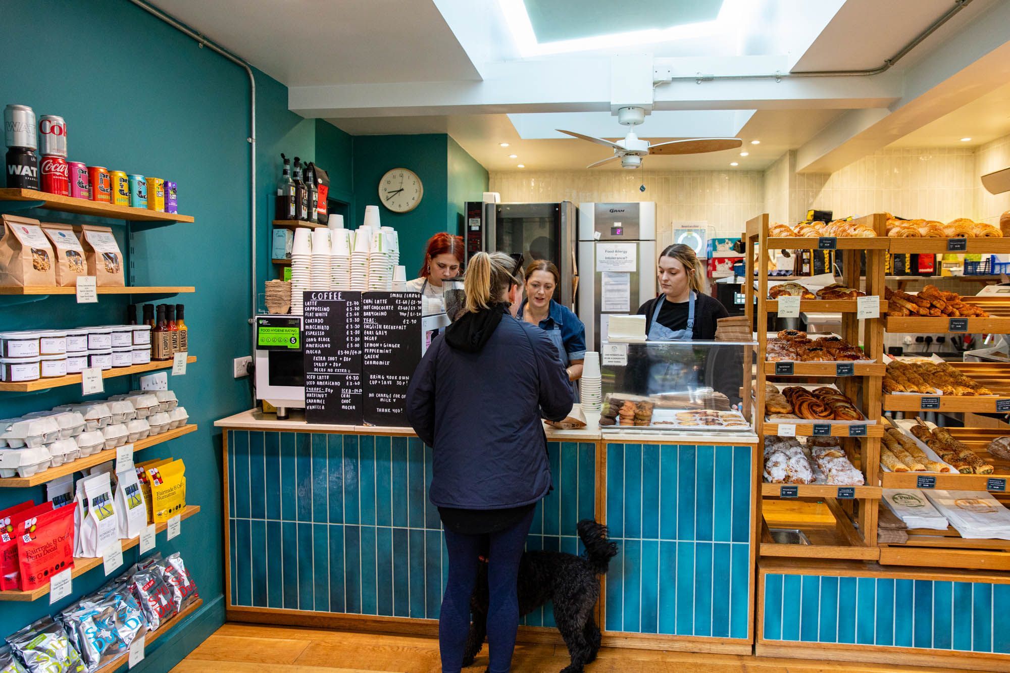 lady with dog paying for her pastries at Open Bakery Queens Park