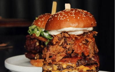 huge burger served on whlte plate
