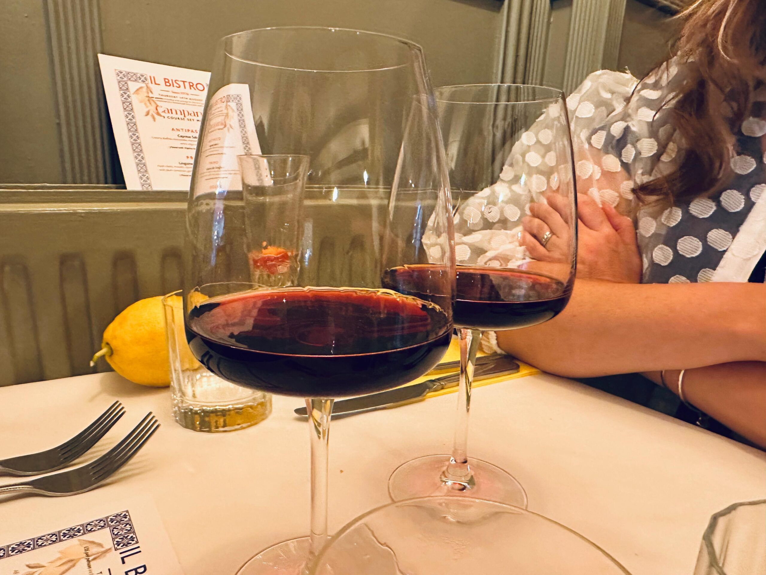 two glasses of red wine at the table, served for A Taste of Sicily – Il Bistro’s New Monthly Supper‑club