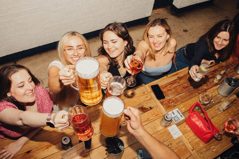A shot taken from above of a group of friends cheersing their drinks.