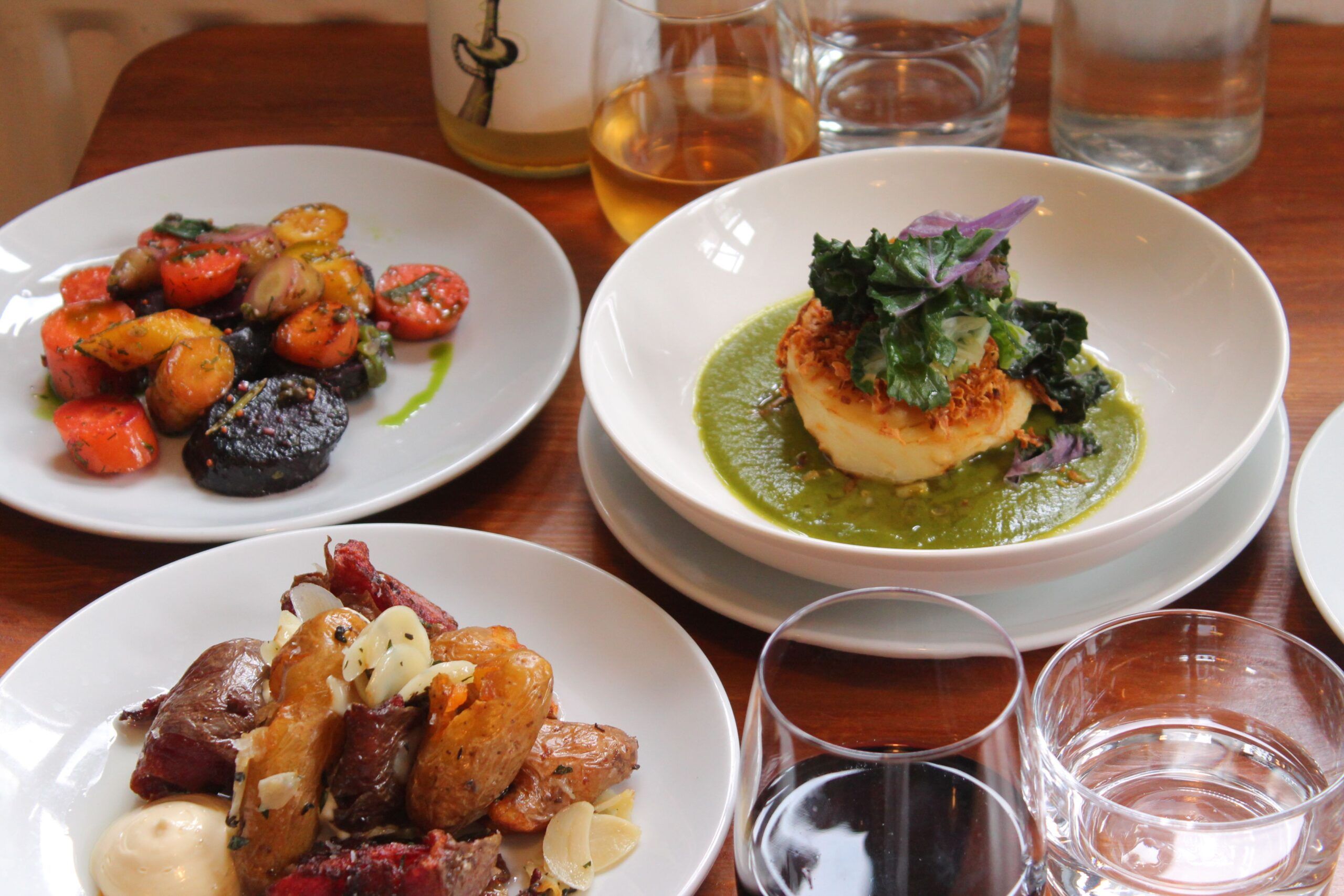 close up shot of three dishes at Dill served with wine