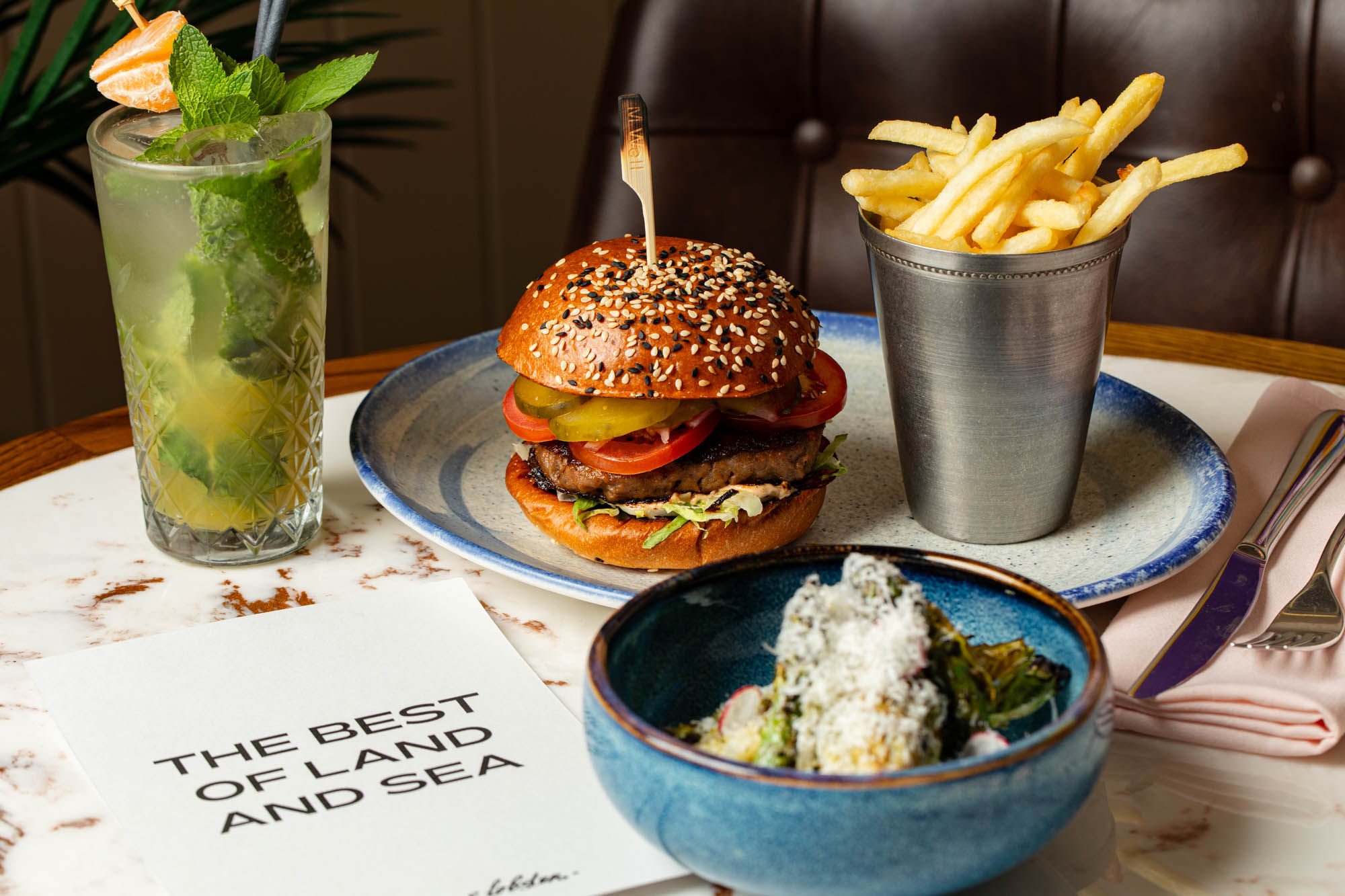 shot of the burger, chips and cocktail served on the table at Burger and Lobster