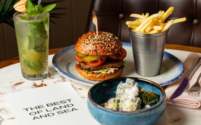 shot of the burger, chips and cocktail served on the table at Burger and Lobster