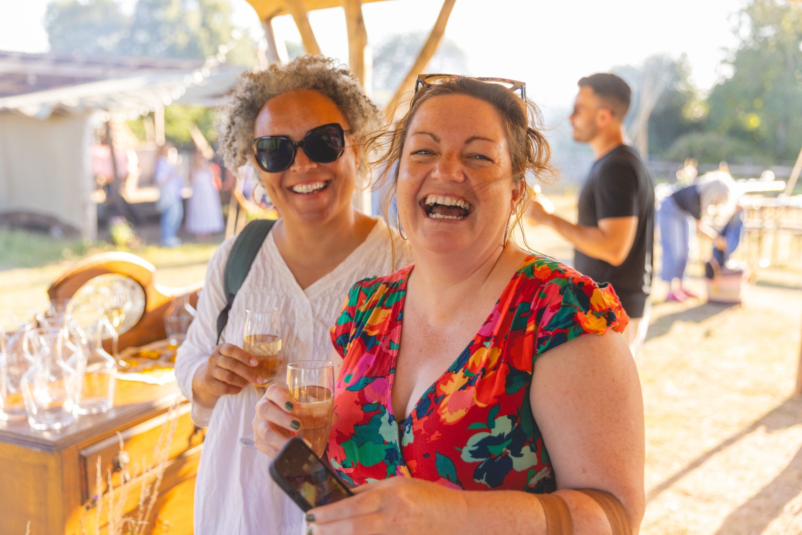 Jude and her friend Jenn having a drink and laughing at the camera