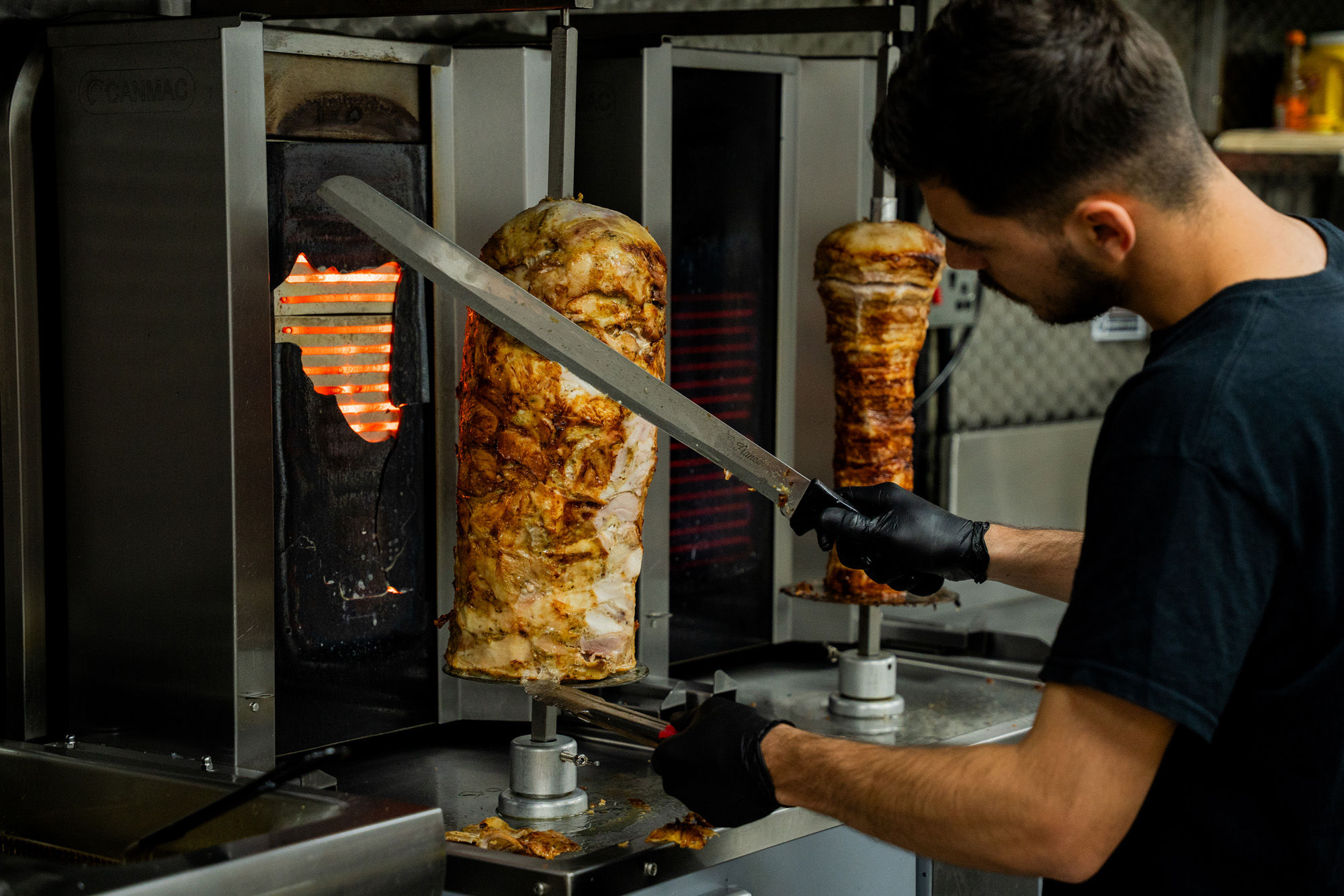a man cutting of the meat of the metal stick at Parthenon Gyros