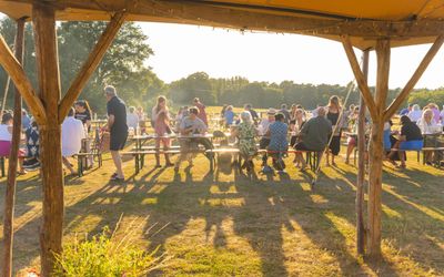 people sitting in the sunset and enjoying feast at Woodfire camping