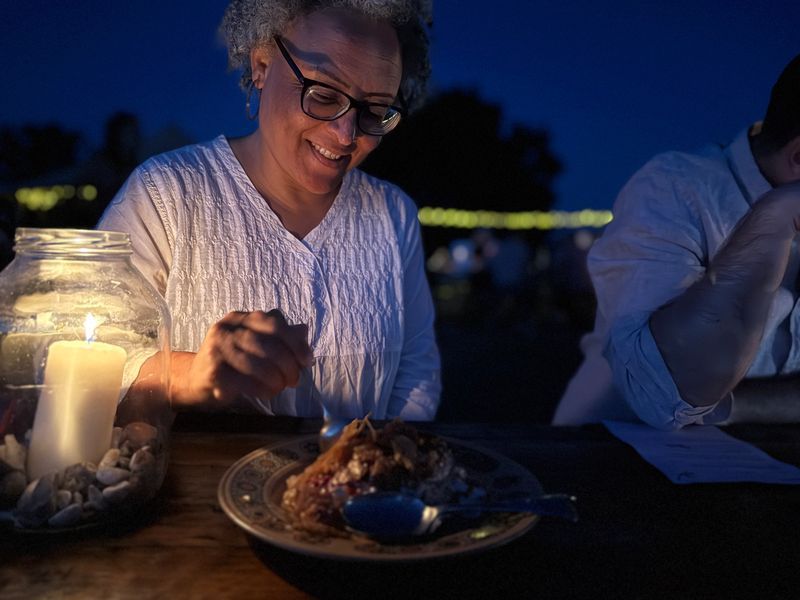 Jenny having a dish by the candle outside 