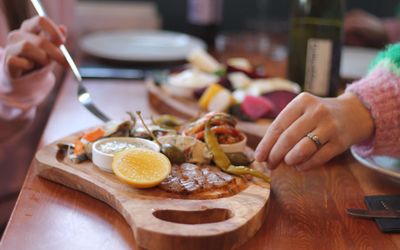 two people sharing food of the wooden board at Dill Lewes