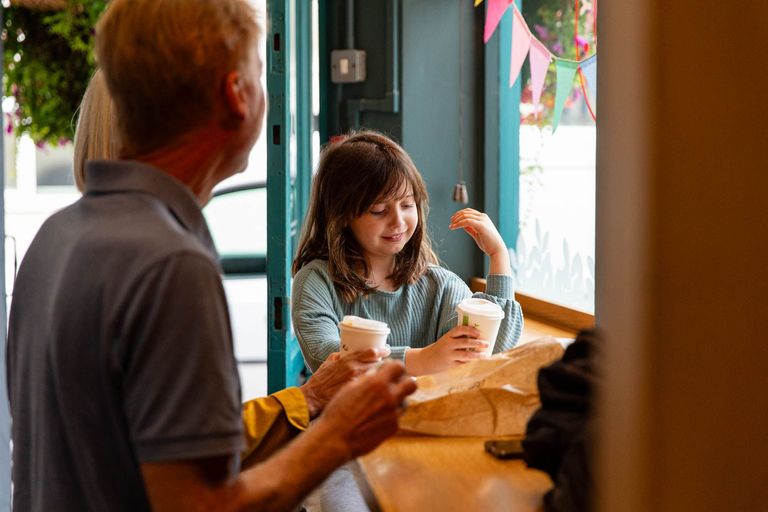 girl having a hot chocolate with her parent