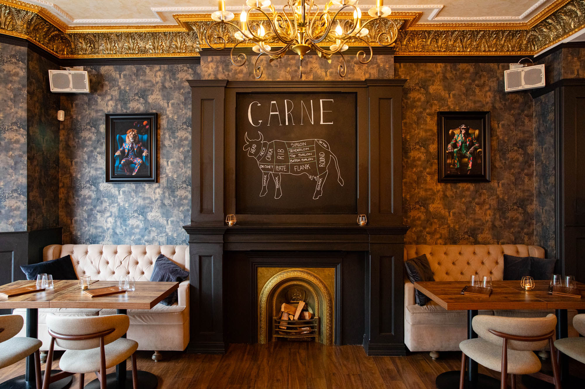interior of Carne in Hove, dim lights, light seating, decorative fire place, paintings on the wall