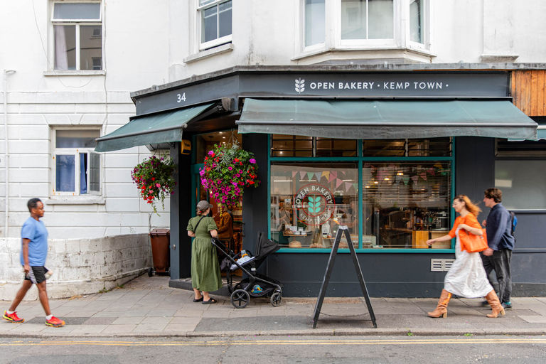 Exterior photo of bakery with people walking by on the street.