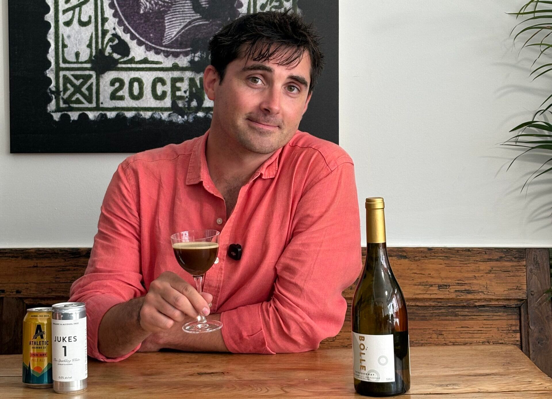 Tom holding glass of wine at the wooden table