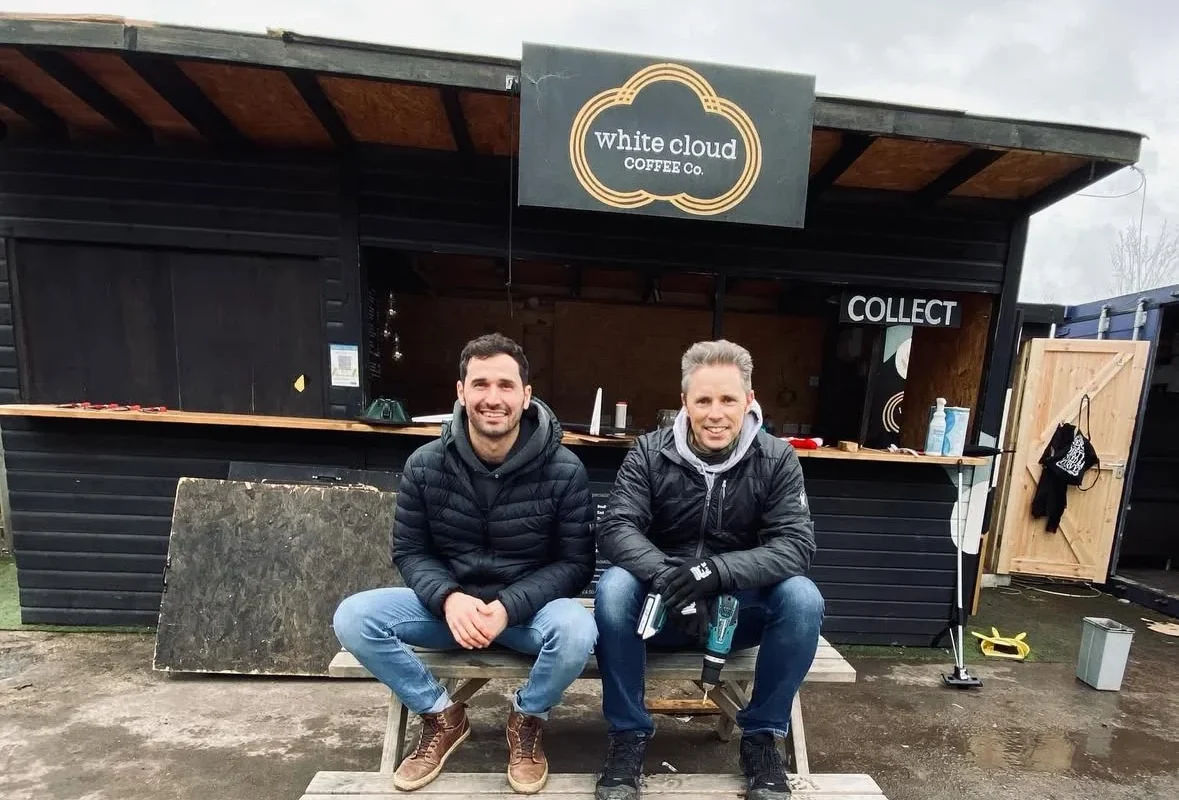 owners of white cloud coffee sitting on the bench