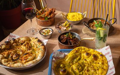 a selection of dishes at Chilli Pickle Brighton, A couple of naan breads alongside smaller dishes.