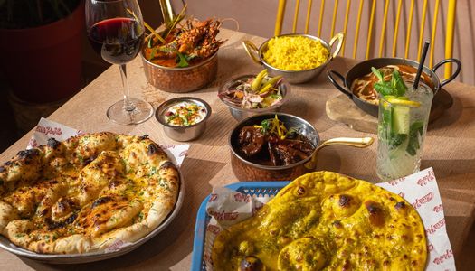 a selection of dishes at Chilli Pickle Brighton, A couple of naan breads alongside smaller dishes. Indian Restaurant Brighton