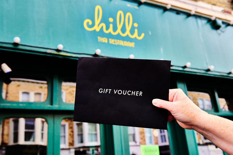 A black envelope held up in front of the green exterior of a Hove restaurant. Restaurants Brighton vouchers - redeemable across a range of Brighton and Hove restaurants