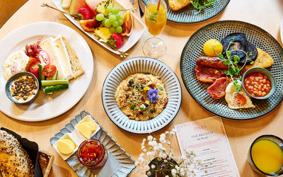 a table is full of breakfast dishes. From a cooked breakfast, fruit, porridge, coffee and more. It all looks very tasty.