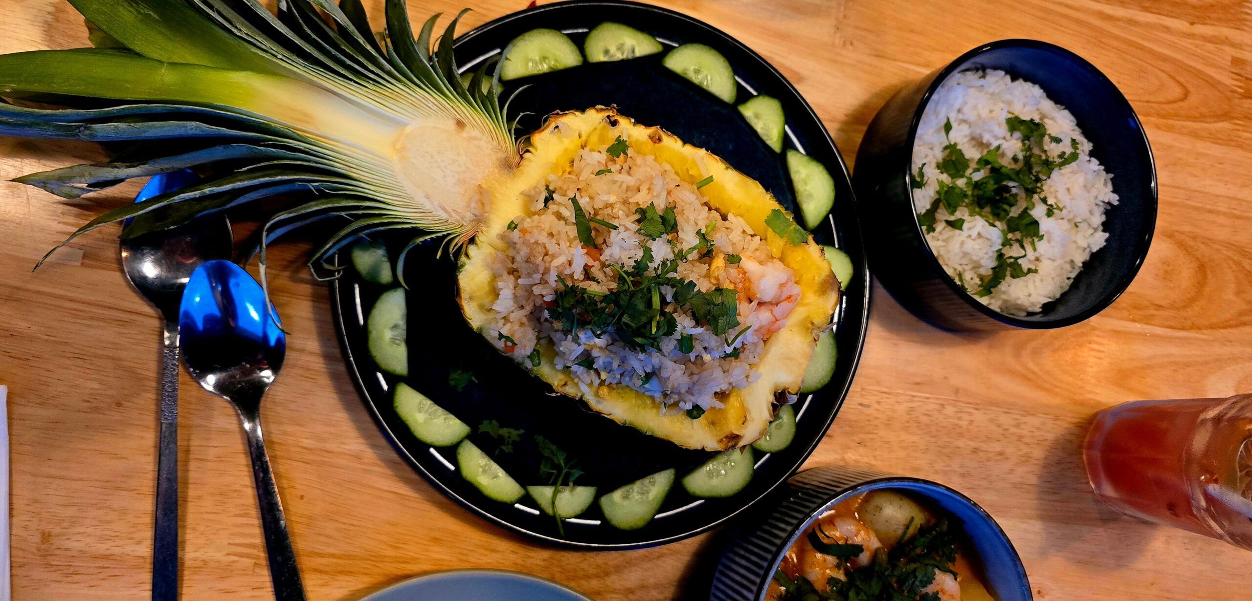 pineapple sliced in half and filled with rice and herbs