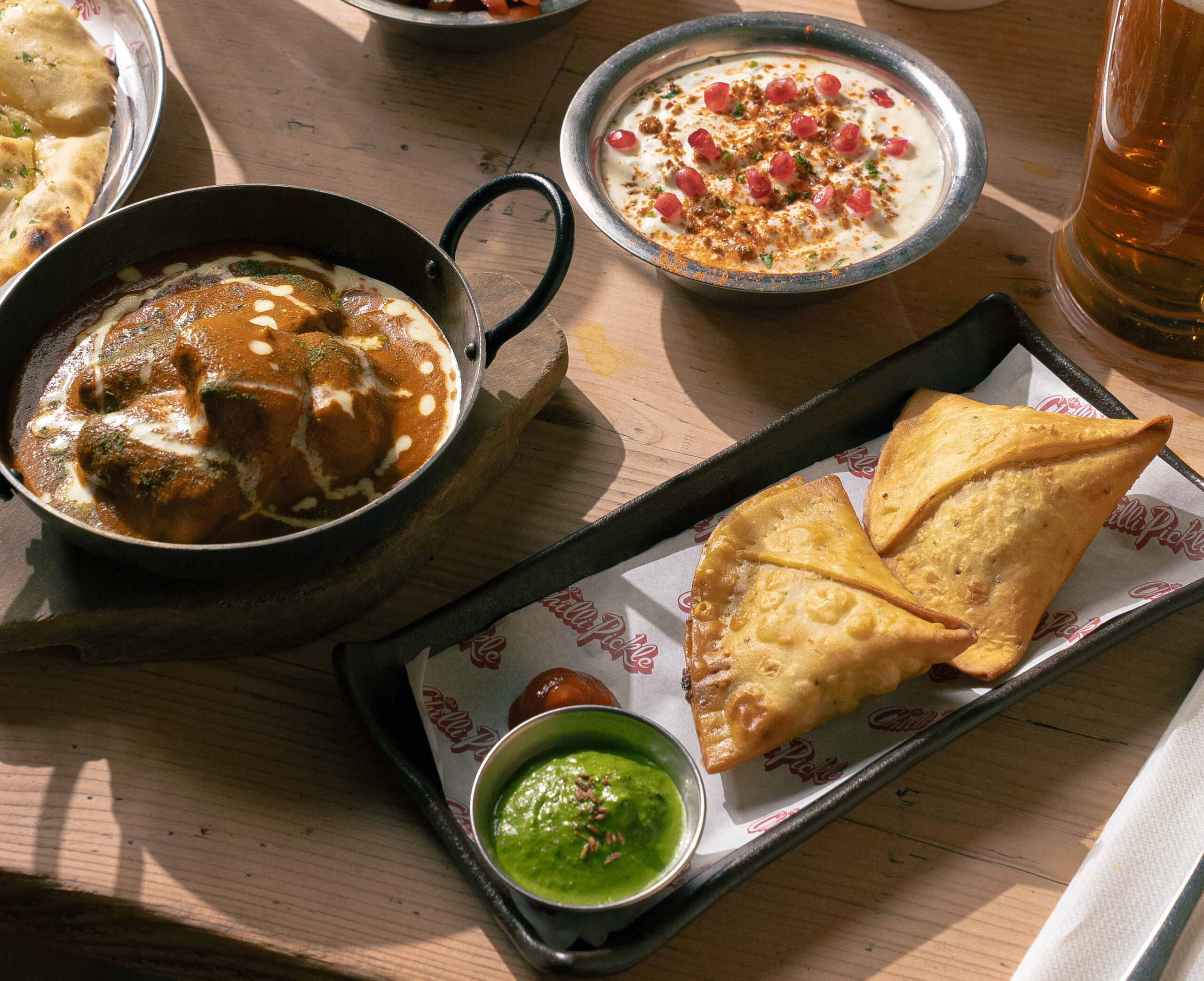 Yoghurt and pomegranate dish alongside Chilli Pickle main dishes