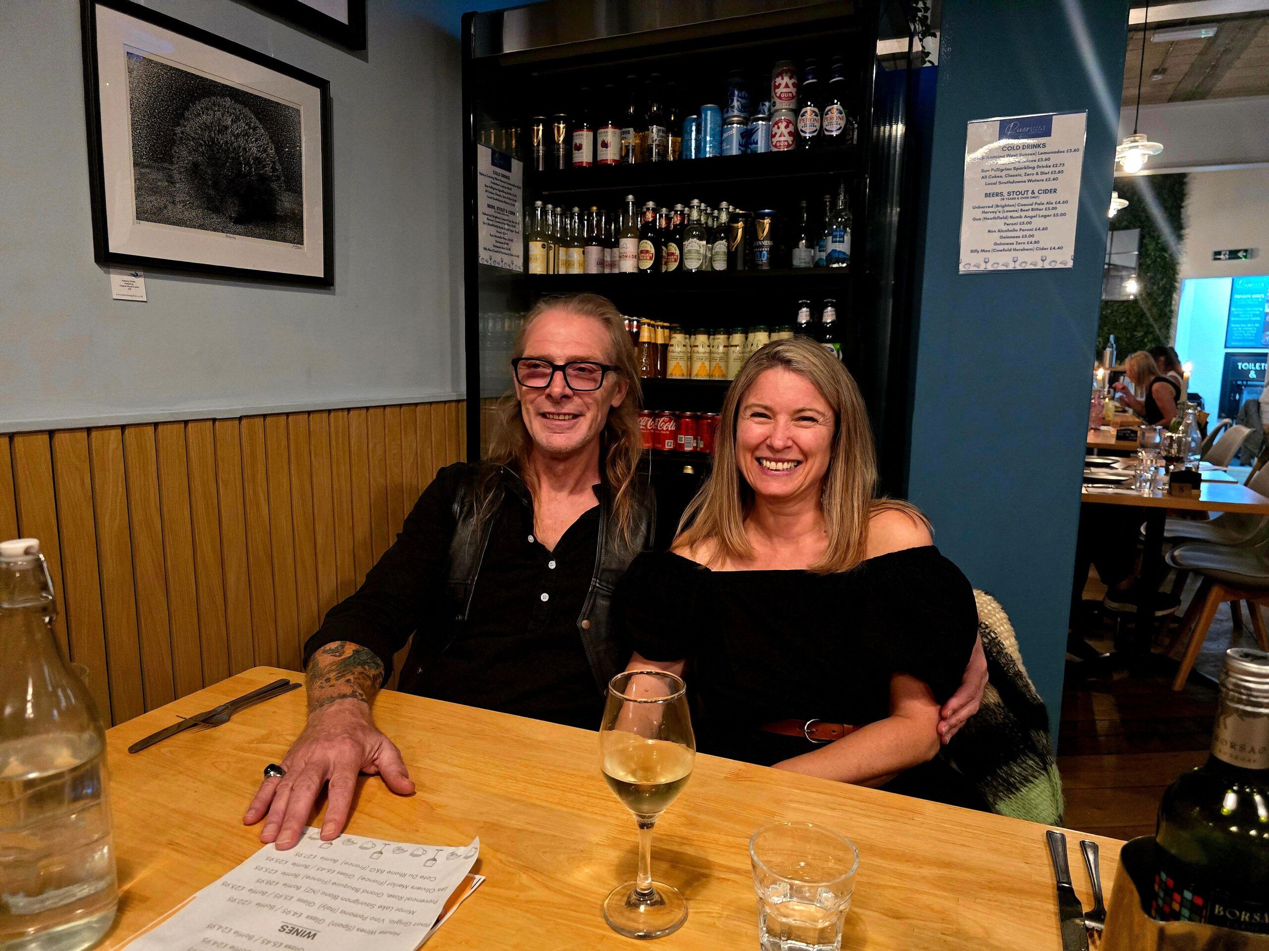 a couple sitting at the table and enjoying wine