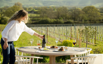 Artelium Kitchen - waiter adding bottle of champage on the table in the yard