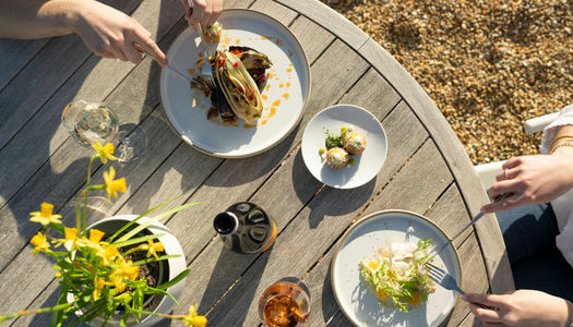 over head shot of the few dishes served on white plates on on round table at Artelium Wine Kitchen