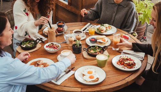 People sat around a large round table at Coppa Club Brighton with lots of dishes of food. Where to eat in Brighton - In Brighton's historic Lanes