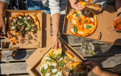over head shot of the three people sharing three pizzas at White Horses