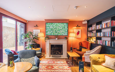 A comfortable space with an open fire, sofas and a rug.