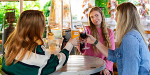 Three ladies enjoying a drink in the garden of Hove pub on an autumnal afternoon.