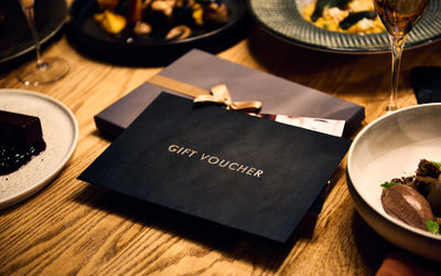 Gift voucher on a table with plates of food laid out around it at Terra Restaurant at Tottington Manor.