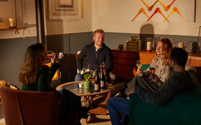 a group of people sat down enjoying a glass of wine