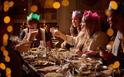 People celebrating a Christmas with party hats and twinkly lights.