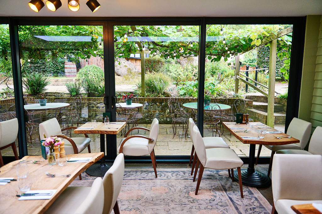 The Jolly Sportsman Pub looking out to the lush garden. Part of our food pubs guide for Brighton, Hove and Sussex.