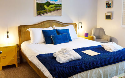 A large bed with white and blue bedding at The Jolly Sportsman Pub, Sussex