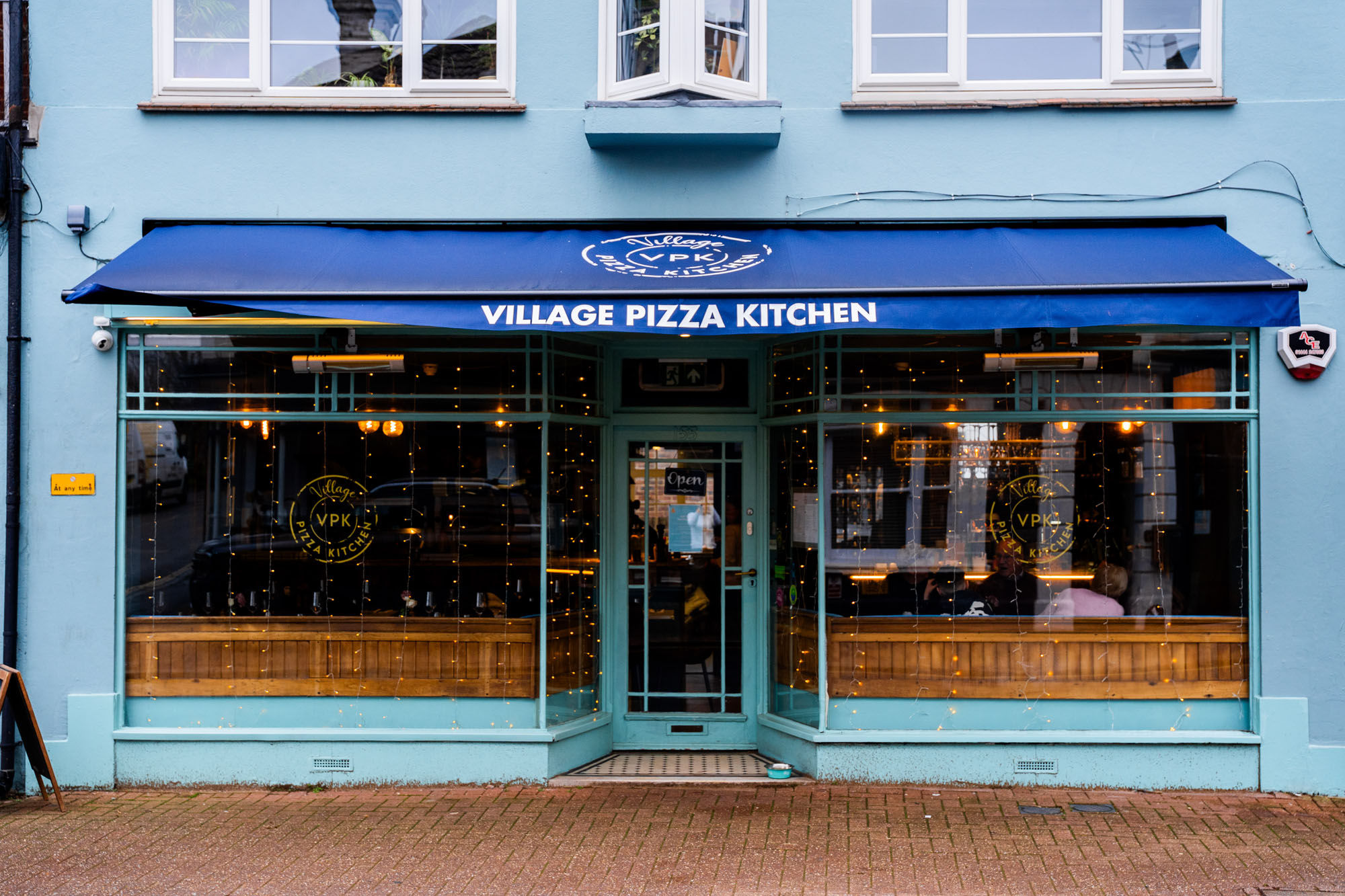 exterior shot of the - Village Pizza Kitchen - blue building